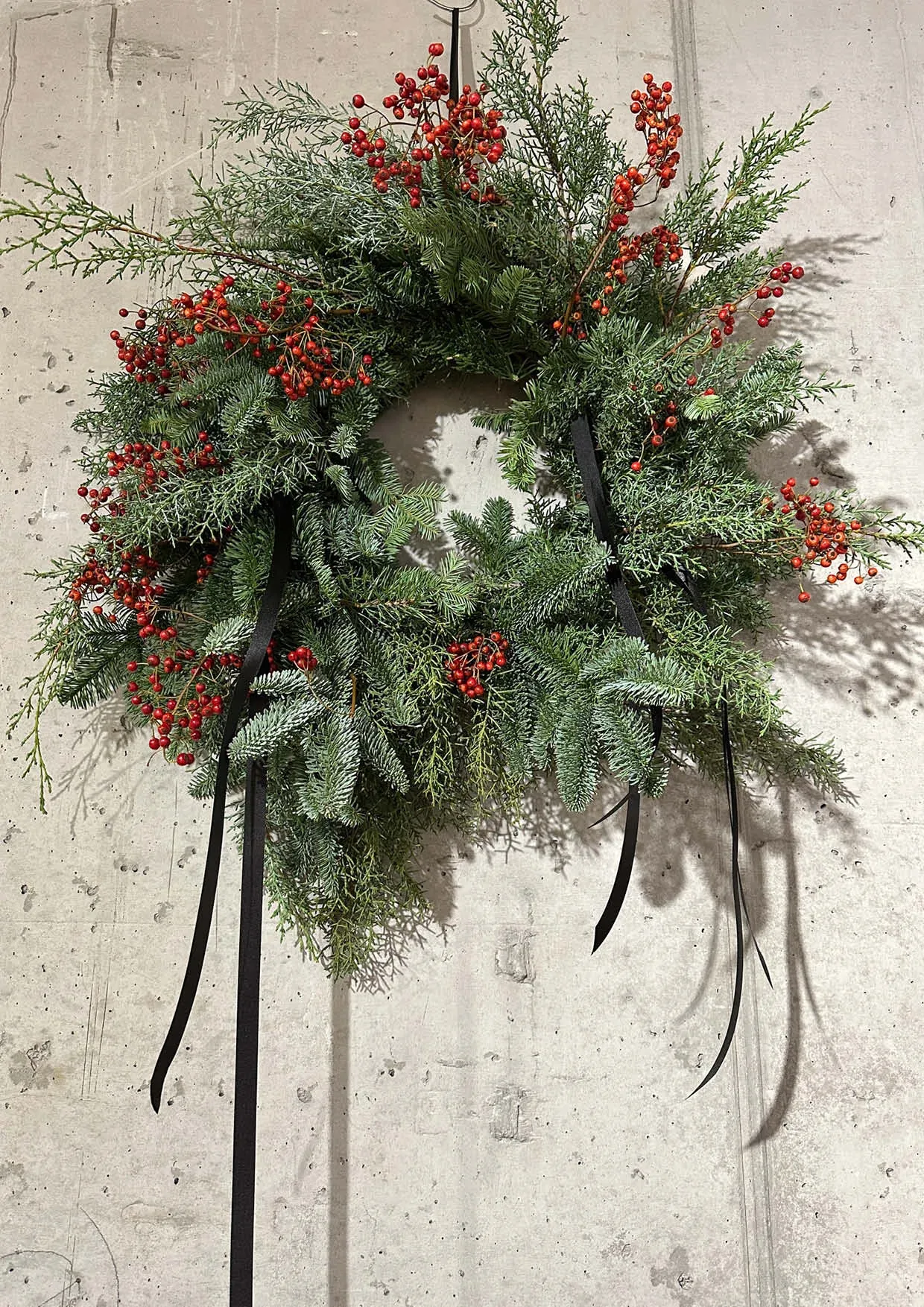 Christmas wreath made of fir branches and black ribbon